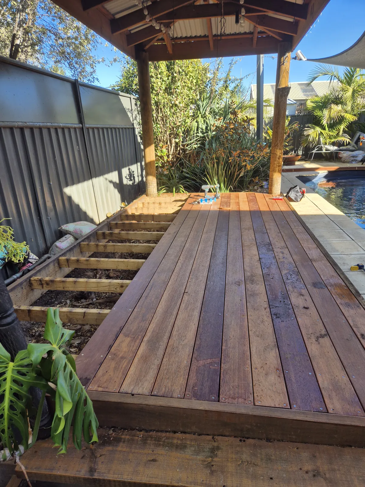 New hardwood deck and steps wrapping the pool