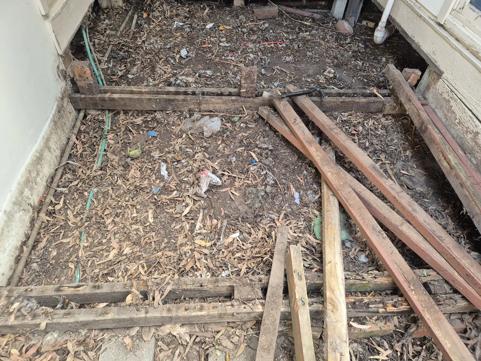 Old deck stripped back — joists removed, ground prepared for new substructure