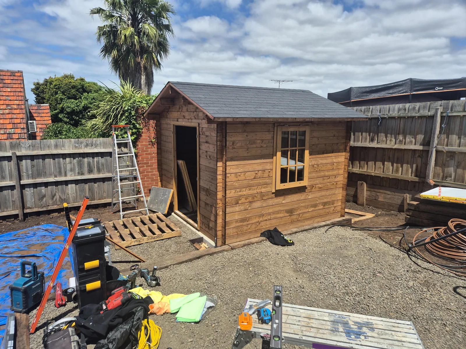 Cabin with shingled roof complete, ready for doors and windows