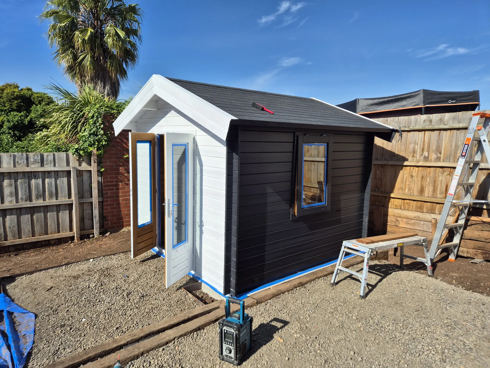 Black top-coat going on with crisp white trim around windows and gable