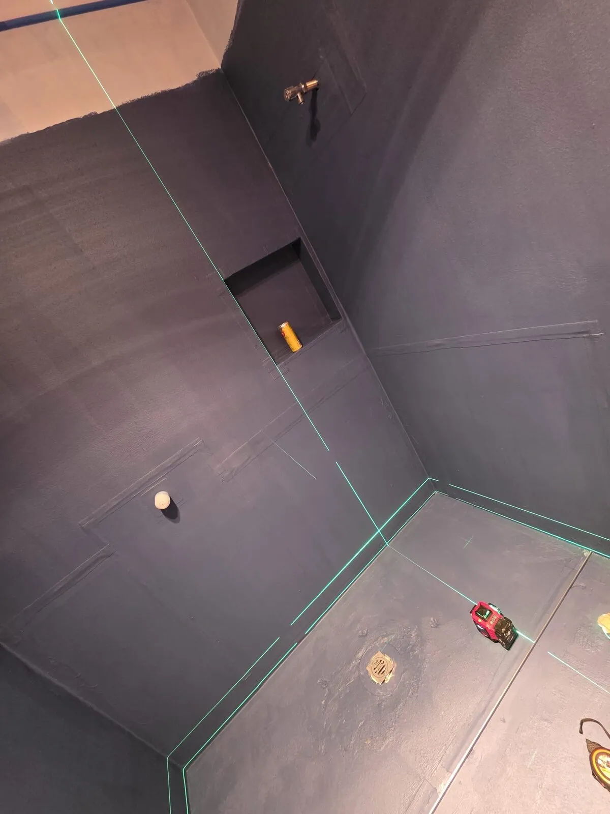 Two-coat waterproofing membrane applied across walls, floor, and shower niche